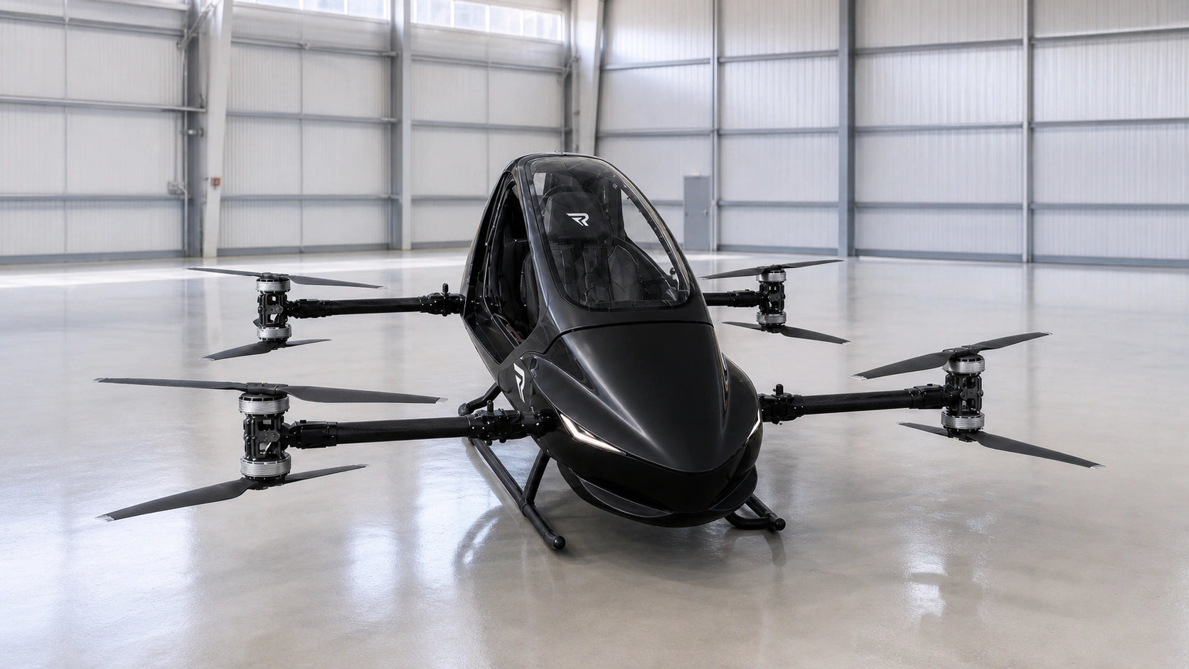 Satin-black REVTOL R3 Plus aircraft in the hangar